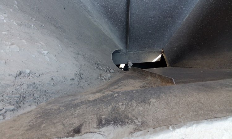 The poor geometry of a pyramid hopper for rock gypsum meant that the operator had to spoon feed material into it from front-end loaders , turning the hopper into a glorified chute.